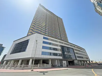 a tall building on the corner of a street at Modern 1 bedroom apartment in Sports City in Dubai
