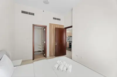 a bedroom with a bed with two pairs of slippers at Modern 1 bedroom apartment in Sports City in Dubai