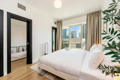 a bedroom with a large white bed and a large window at FAM Living - Panoramic Dubai Marina View apartment in Dubai