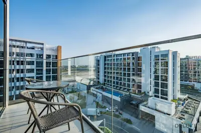 a balcony with a table and chair on a building at Appealing Studio Apartment at Azizi Riviera 34, Al Merkadh by Deluxe Holiday Homes in Dubai