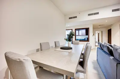 a dining room with a table and chairs at 2BD apartment near the beach in Bahar, JBR in Dubai