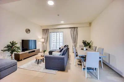 a living room with a table and a dining room at 2BD apartment near the beach in Bahar, JBR in Dubai