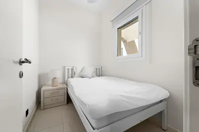 a white bedroom with a bed and a window at Stonetree - The Springs 5 - Peaceful Community in Dubai