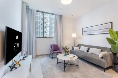 a living room with a couch and a tv at STAY BY LATINEM Luxury 1BR Holiday Home CV B803 near Burj Khalifa in Dubai