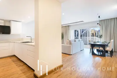 a kitchen and a living room with a table at LUX The Bonnington JLT Suite in Dubai