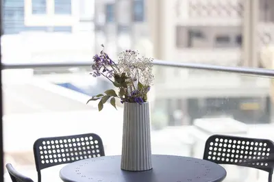 a vase with purple flowers sitting on a table at Lux 1BR,5 Min to Burj Khalifa In heart of Downtown - South Ridge Tower in Dubai