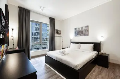 a bedroom with a bed and a large window at Lux 1BR,5 Min to Burj Khalifa In heart of Downtown - South Ridge Tower in Dubai