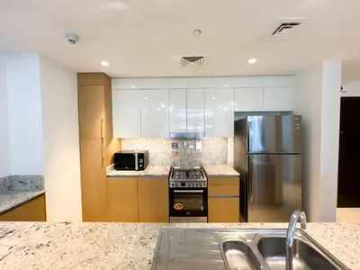 a kitchen with a stainless steel refrigerator and a stove at Luxurious New Brand 2Br at Mulberry 2 at Park Heights Building A2 - Dubai Hills in Dubai