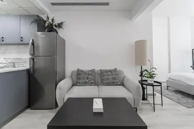 a living room with a couch and a refrigerator at HAVN - Studio with Lake Views in Dubai Gate, JLT in Dubai