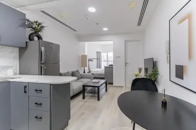 a kitchen and living room with a couch and a table at HAVN - Studio with Lake Views in Dubai Gate, JLT in Dubai