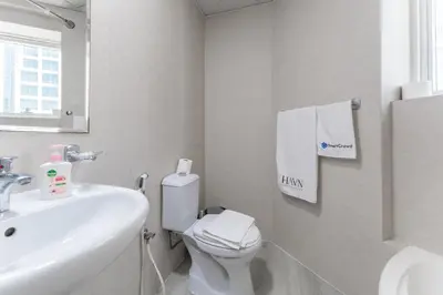 a white bathroom with a toilet and a sink at HAVN - Studio with Lake Views in Dubai Gate, JLT in Dubai