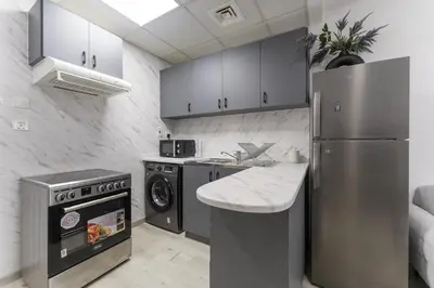 a kitchen with a stainless steel refrigerator and a dishwasher at HAVN - Studio with Lake Views in Dubai Gate, JLT in Dubai