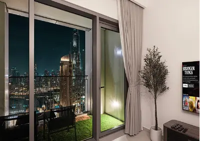 a room with a window with a view of a city at Downtown Burj Khalifa View 2BR Apartment in Dubai