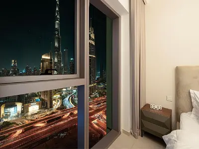 a bedroom with a window with a view of a city at Downtown Burj Khalifa View 2BR Apartment in Dubai