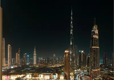 a city skyline at night with a tall building at Downtown Burj Khalifa View 2BR Apartment in Dubai