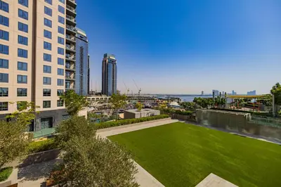 a green lawn in the middle of a city with buildings at Burj Khalifa view & Creek sea view in Dubai