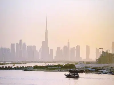 a city skyline with a boat in the water at Burj Khalifa view & Creek sea view in Dubai