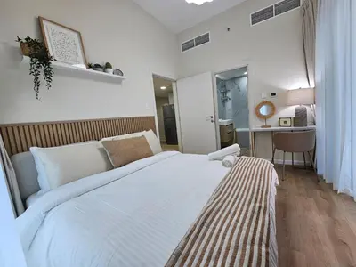 a bedroom with a large white bed with a desk at Golden Hour Marina View in Dubai