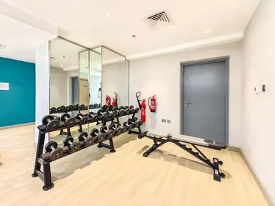 a gym with a row of treadmills and a mirror at Zen Condo With Burj Khalifa View In Vibrant City in Dubai