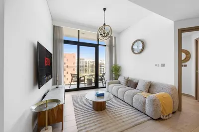 a living room with a couch and a table at Zen Condo With Burj Khalifa View In Vibrant City in Dubai
