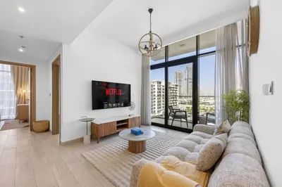 a living room with a couch and a tv at Zen Condo With Burj Khalifa View In Vibrant City in Dubai