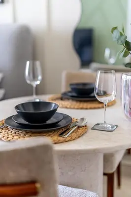a table with two wine glasses and plates on it at GuestReady - Downtown Dubai luxurious living in Dubai