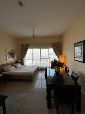 a living room with a bed and a dining room table at Ashri HH, Studio in JVC in Dubai