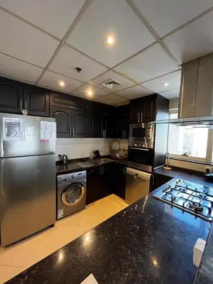 a kitchen with a stainless steel refrigerator and a dishwasher at Ashri HH, Studio in JVC in Dubai
