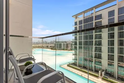 a balcony with a view of a pool and a building at Premium 1-BR with Exquisite Layout in District One in Dubai