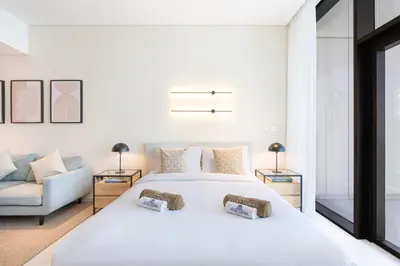 a bedroom with a white bed and a couch at Cozy Central Home with Full Burj View in Dubai