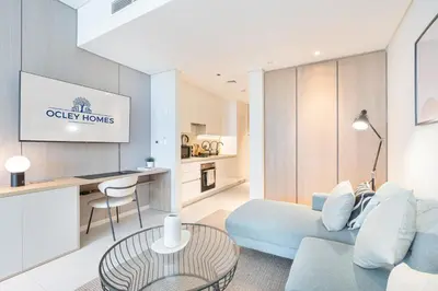 a living room with a blue couch and a table at Cozy Central Home with Full Burj View in Dubai