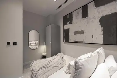 a bedroom with a bed and a painting on the wall at Palm Penthouse Sky Villa - Vast Terrace & Jacuzzi by Exclusive Holiday Homes in Dubai