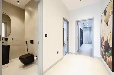a bathroom with a black toilet and a hallway at Palm Penthouse Sky Villa - Vast Terrace & Jacuzzi by Exclusive Holiday Homes in Dubai