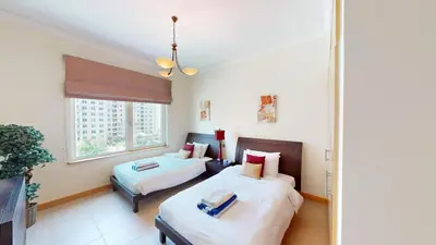 a bedroom with two beds and a window at Dabas Palm Shores Elegant Four Beds in Dubai