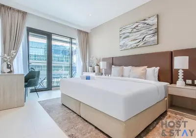 a bedroom with a large white bed and a balcony at Luxurious 1BR Palm Seven, Palm Jumeirah in Dubai