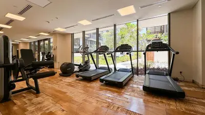 a gym with several treadmills and elliptical machines at Experience City Walk - Spacious Haven - 2 Bedroom plus Maid's Room in Dubai