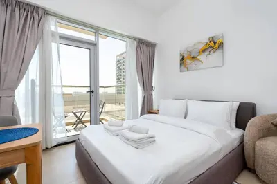 a bedroom with a large white bed and a window at Nice studio in Al Furjan - Dubai in Dubai