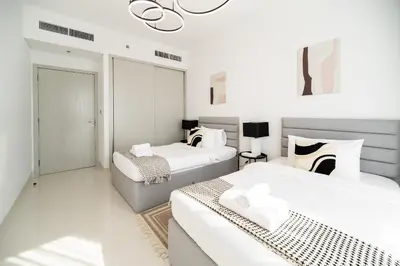 a bedroom with two beds and a chandelier at SettlerHomes - Breathtaking View With Private Beach in Dubai