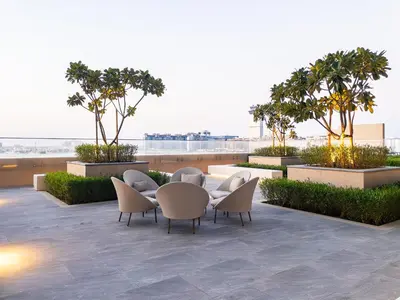 a patio with a table and chairs and trees at SettlerHomes - Breathtaking View With Private Beach in Dubai