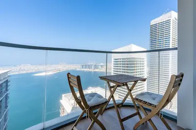 a table and chairs on a balcony with a view of the water at Beachfront 2-BDR, High floor, Sea and Palm View, Beach Access in Dubai