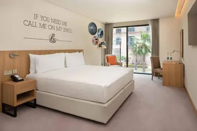 a bedroom with a large white bed and a desk at Rove JBR in Dubai
