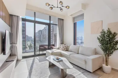 a living room with a white couch and large windows at Elegant 1BR Retreat in Riviera 36 Near Downtown in Dubai
