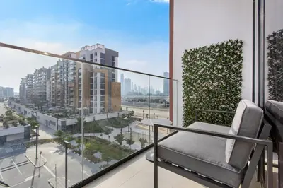 a balcony with a chair and a view of a city at Elegant 1BR Retreat in Riviera 36 Near Downtown in Dubai
