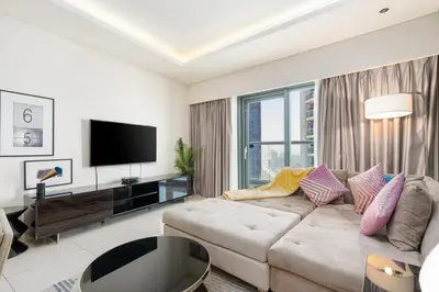 a living room with a couch and a flat screen tv at GLOBALSTAY DAMAC Majestine Apartments in Dubai