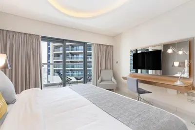 a hotel room with a bed and a desk with a television at GLOBALSTAY DAMAC Majestine Apartments in Dubai