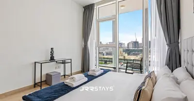a bedroom with a bed and a large window at Stunning Luxury 1BR - Modern with Pool View - JVC in Dubai