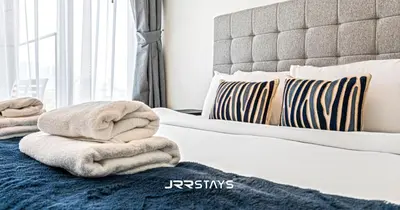 a bedroom with a bed with towels on it at Stunning Luxury 1BR - Modern with Pool View - JVC in Dubai