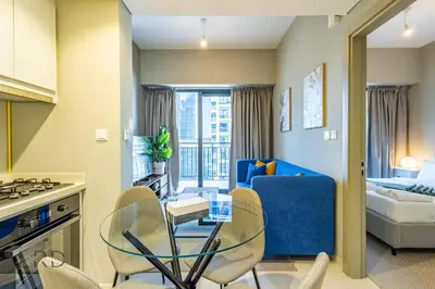a kitchen and living room with a table and chairs at Cozy & Radiant 1BR Business Bay in Dubai