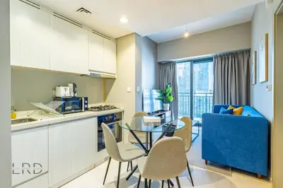 a kitchen and dining room with a table and chairs at Cozy & Radiant 1BR Business Bay in Dubai