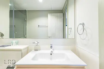 a white bathroom with a sink and a mirror at Cozy & Radiant 1BR Business Bay in Dubai